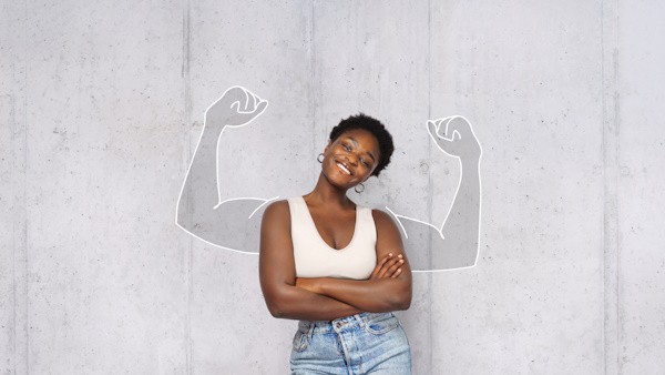 portrait of young happy afro woman looks in camera and shows muscles. success concept.